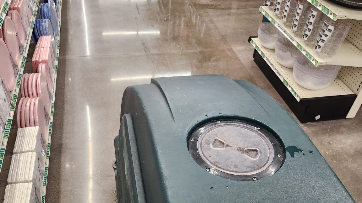 Walk-behind Tennant autoscrubber operating on polished concrete in a large-format retail floor