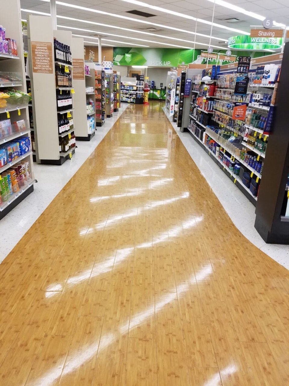 Polished bamboo-look VCT floor in pharmacy retail aisle, AUS maintenance program