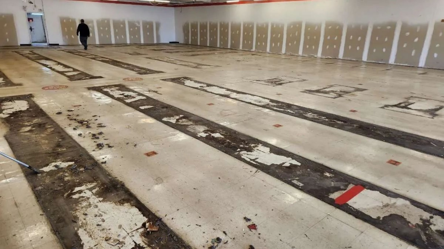 Pre-strip floor condition with debris and adhesive residue prior to restoration; AUS technician on site