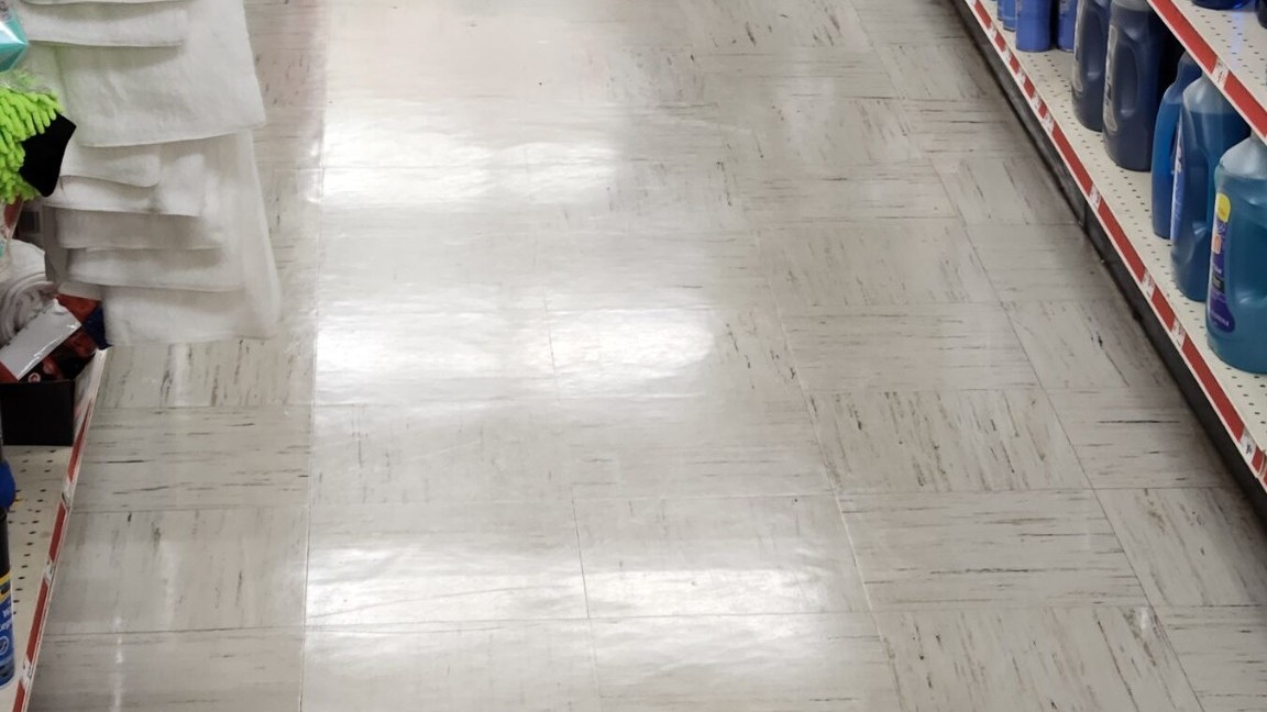 Polished VCT in a Family Dollar retail aisle under recurring scrub program
